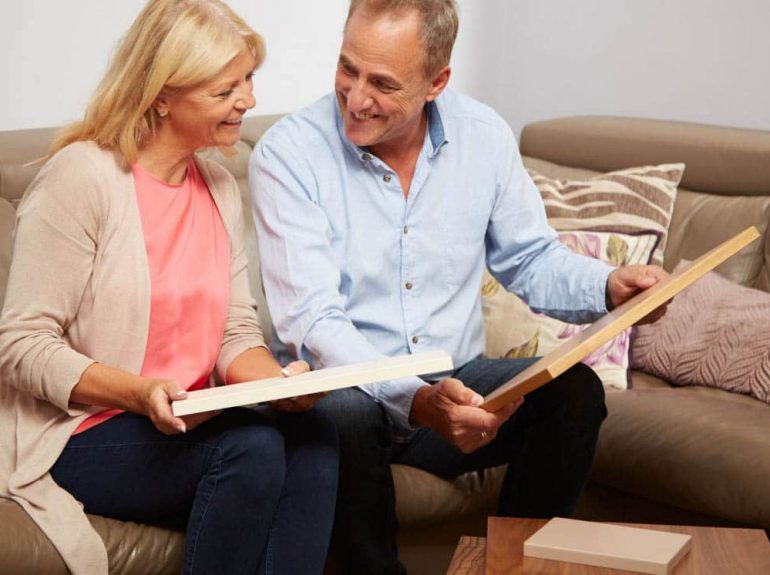 Couple inspecting wood samples in free design consultation