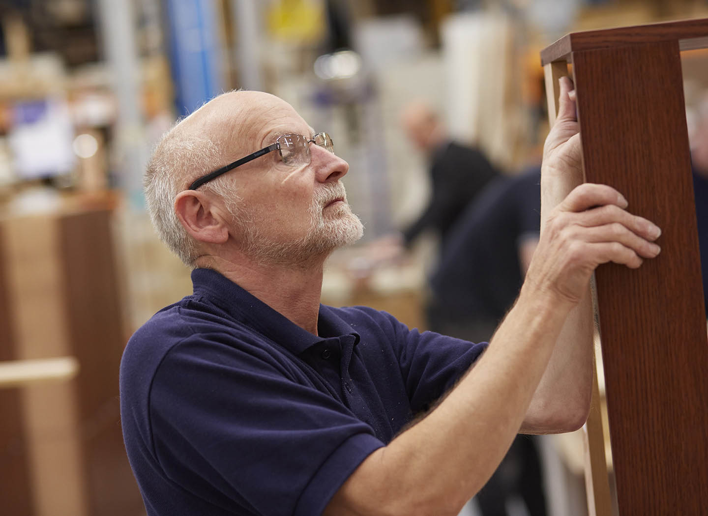 One of our craftsmen inspecting furniture in our Strachan Leeds workshop