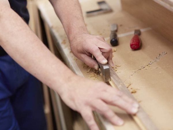 Attention to detail - a workman sanding a furniture piece down Attention to detail - a workman sanding a furniture piece down