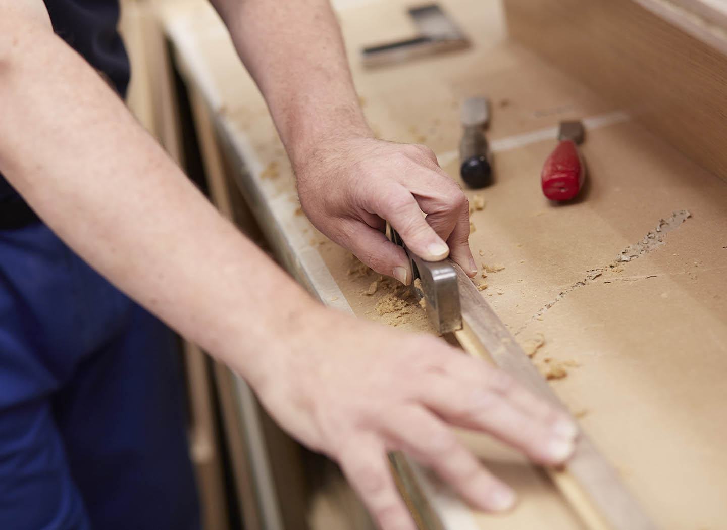 Attention to detail - a workman sanding a furniture piece down