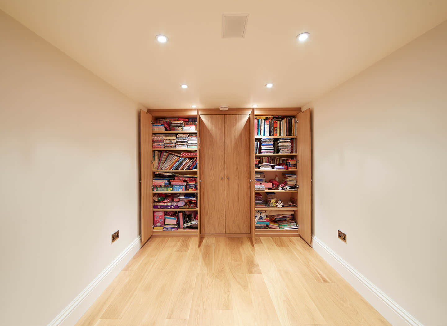 Case study showing fitted cupboard and bookshelves in basement conversion