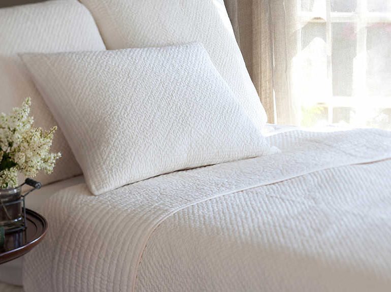 Bed linen and throw in neutral colour scheme