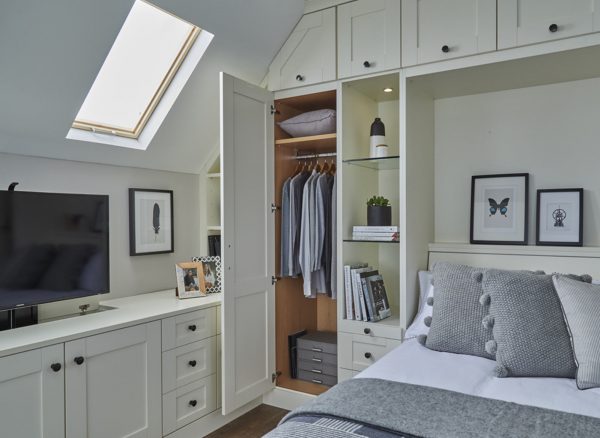 Classic, white fitted bedroom with wall bed and open wardrobe showing interior storage