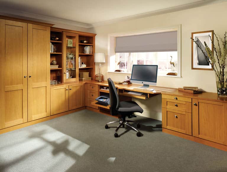 A classic oak breakfront desk fitted next to a window