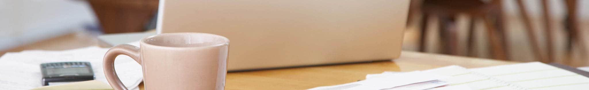Detail of bespoke office desk with laptop and coffee mug